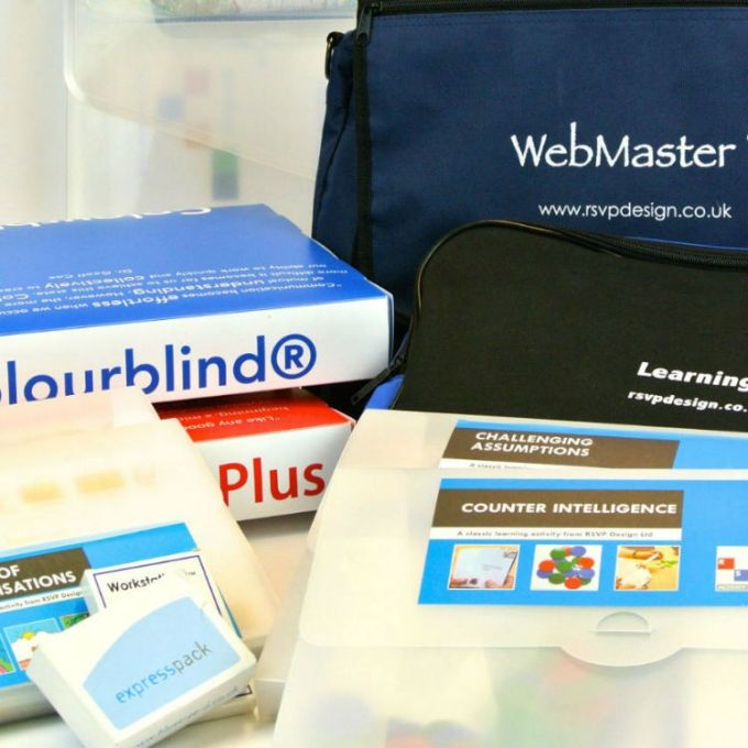Collection of educational package materials including a box labeled 'Colourblind' and a bag with 'WebMaster' branding.