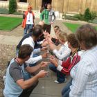 Helium Stick icebreaker and teambuilding experiential learning activity gameplay shot participants crouching
